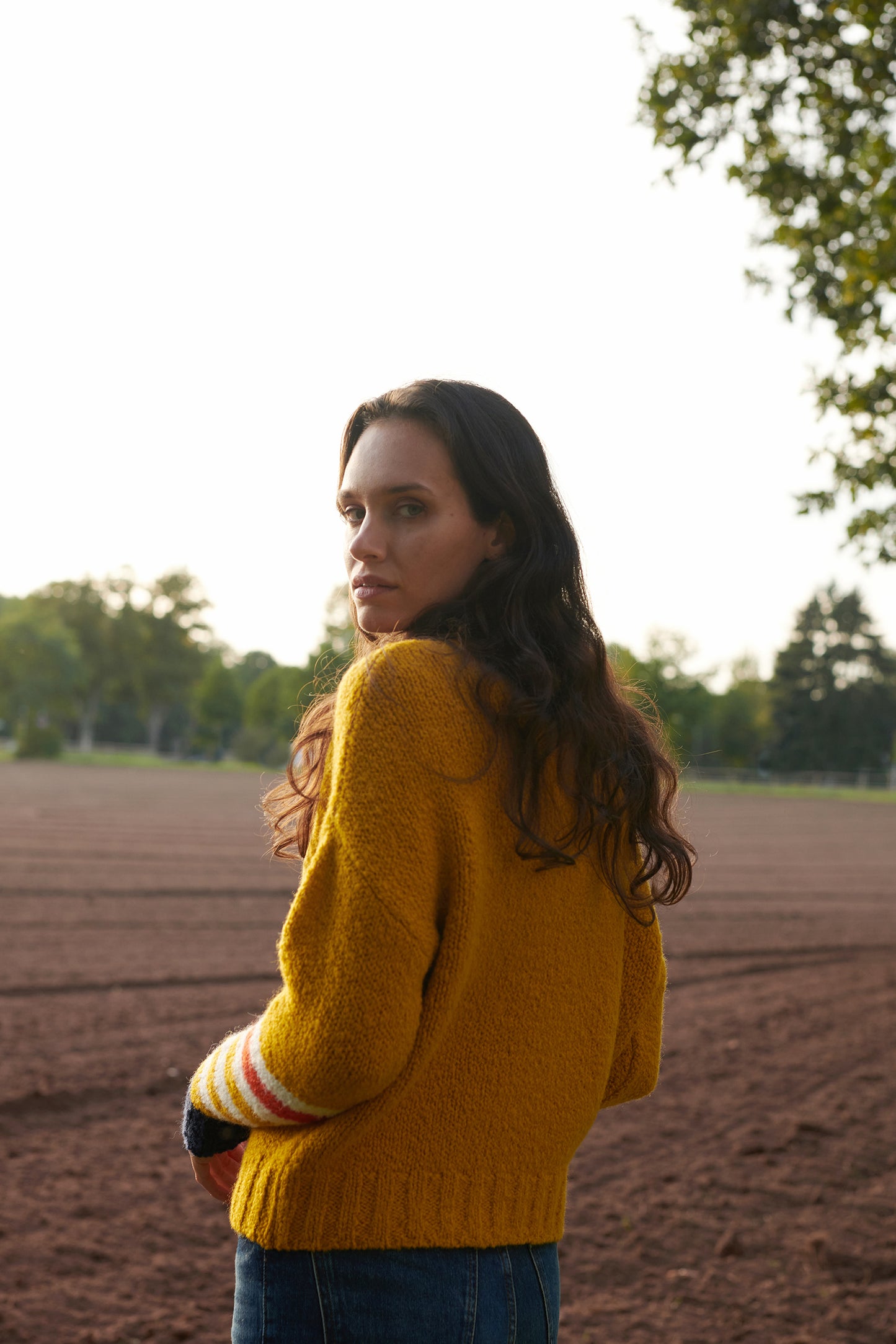 Boucle Pullover VIOLA mit farbigem Ringeldetail und Kontrastabschluessen an Aermel Rueckansicht1 an Model in der Farbe gelb