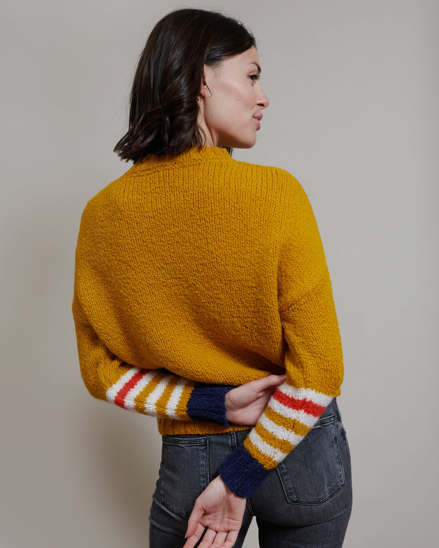 Boucle Pullover VIOLA mit farbigem Ringeldetail und Kontrastabschluessen an Aermel Rueckansicht2 an Model in der Farbe gelb