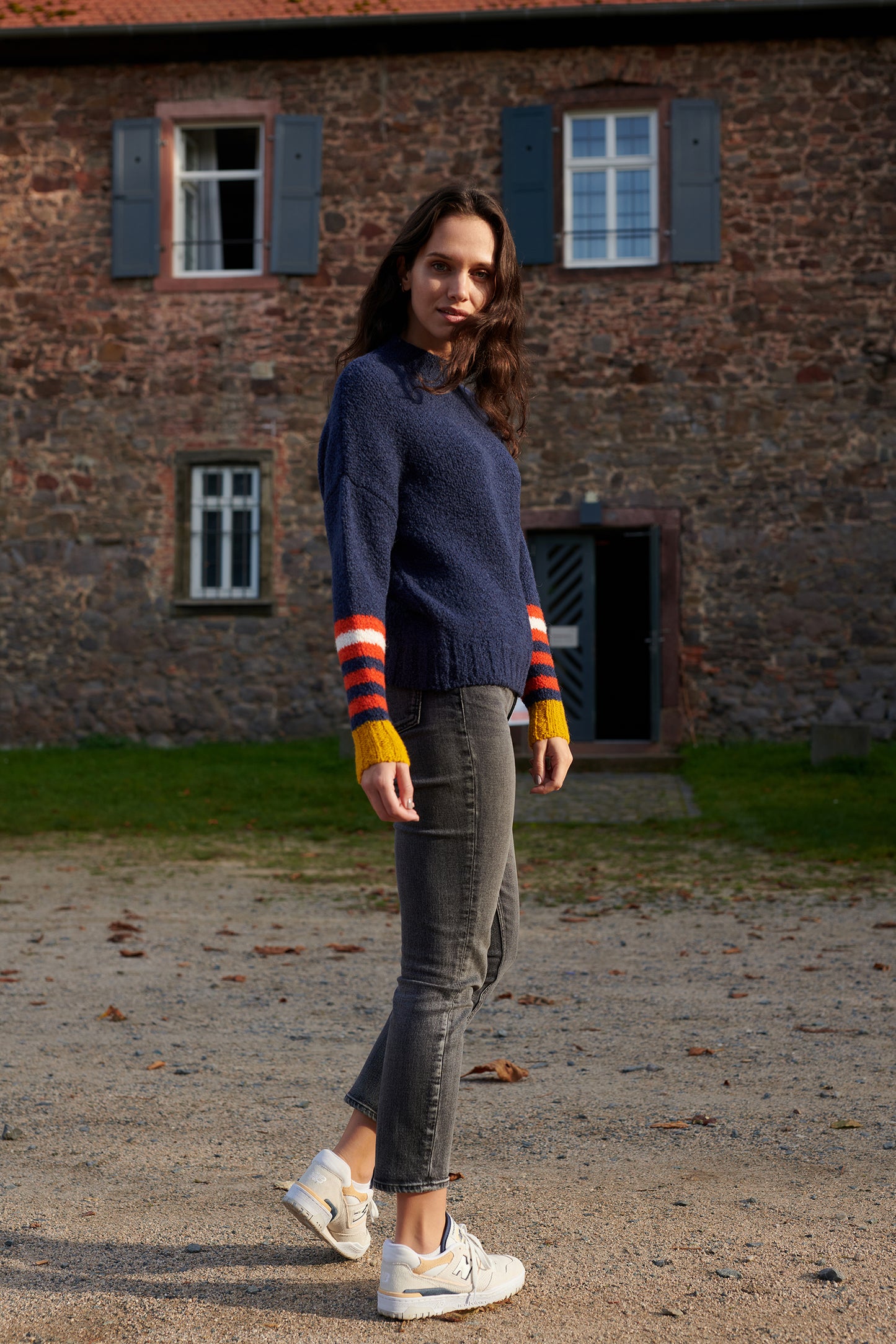 Boucle Pullover VIOLA mit farbigem Ringeldetail und Kontrastabschluessen an Aermel Seitenansicht1 an Model in der Farbe dunkelblau