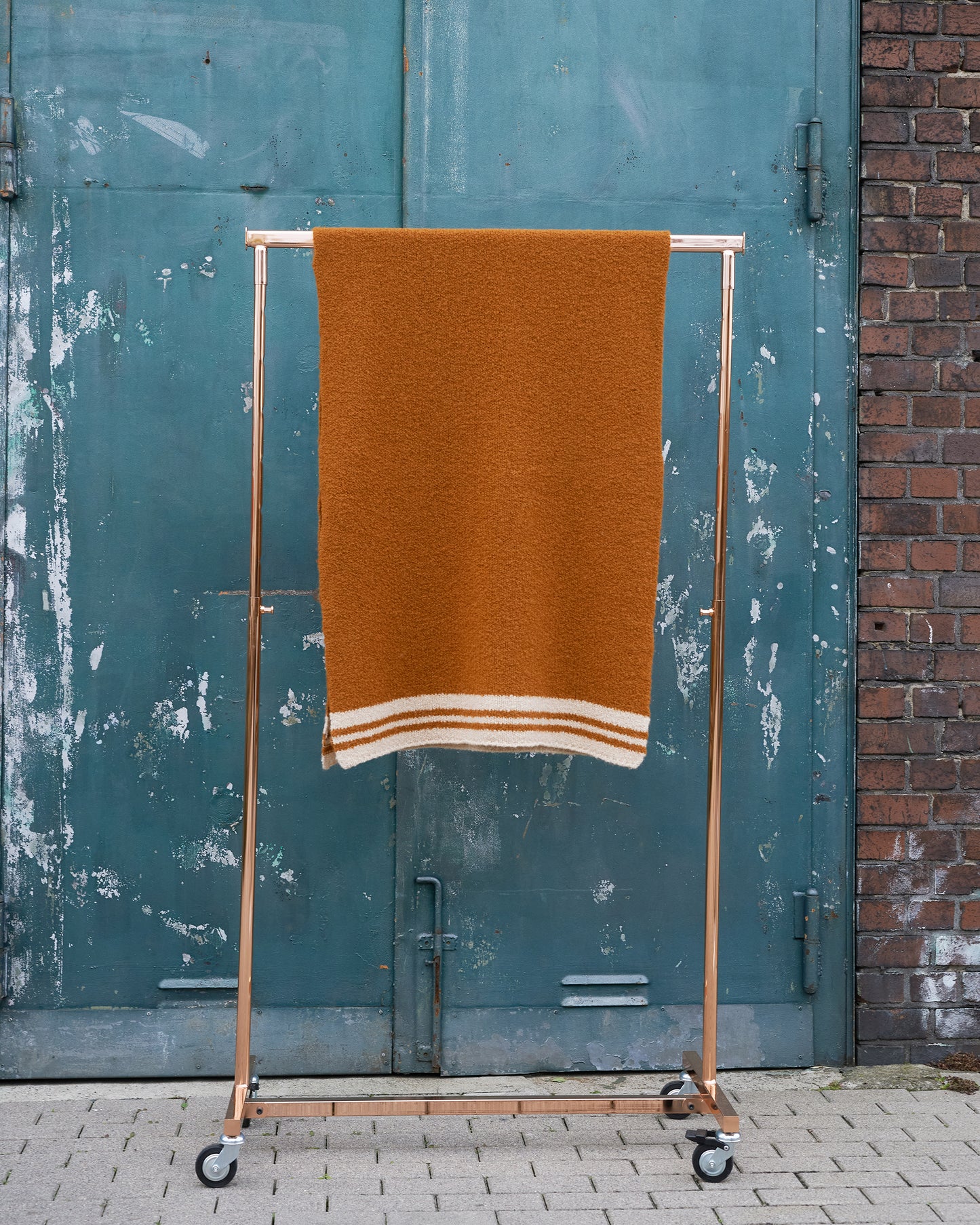 Boucle Schal SALLY mit hellen Collegestreifen ueber Kleiderstange haengend in der Farbe cognac