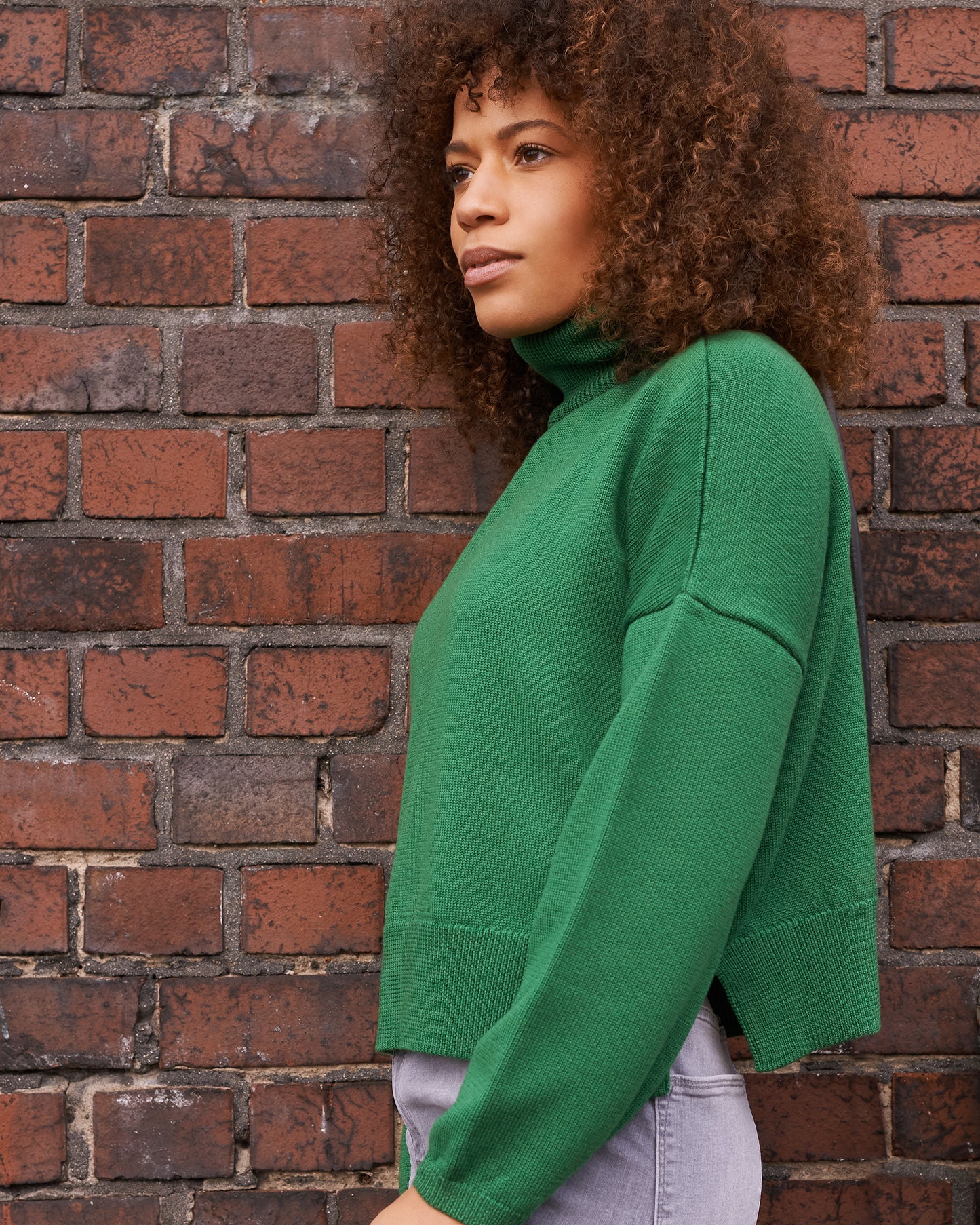 Merino Rollkragenpullover_BEA mit Schlitz in Seitennaht Seitenansicht2 an Model in der Farbe tanne