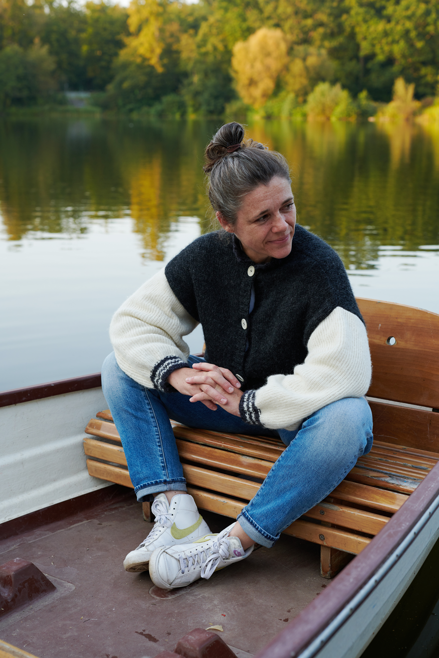 Alpaka College Cardigan VIVIAN an Model in Boot sitzend in der Farbe natur anthrazit