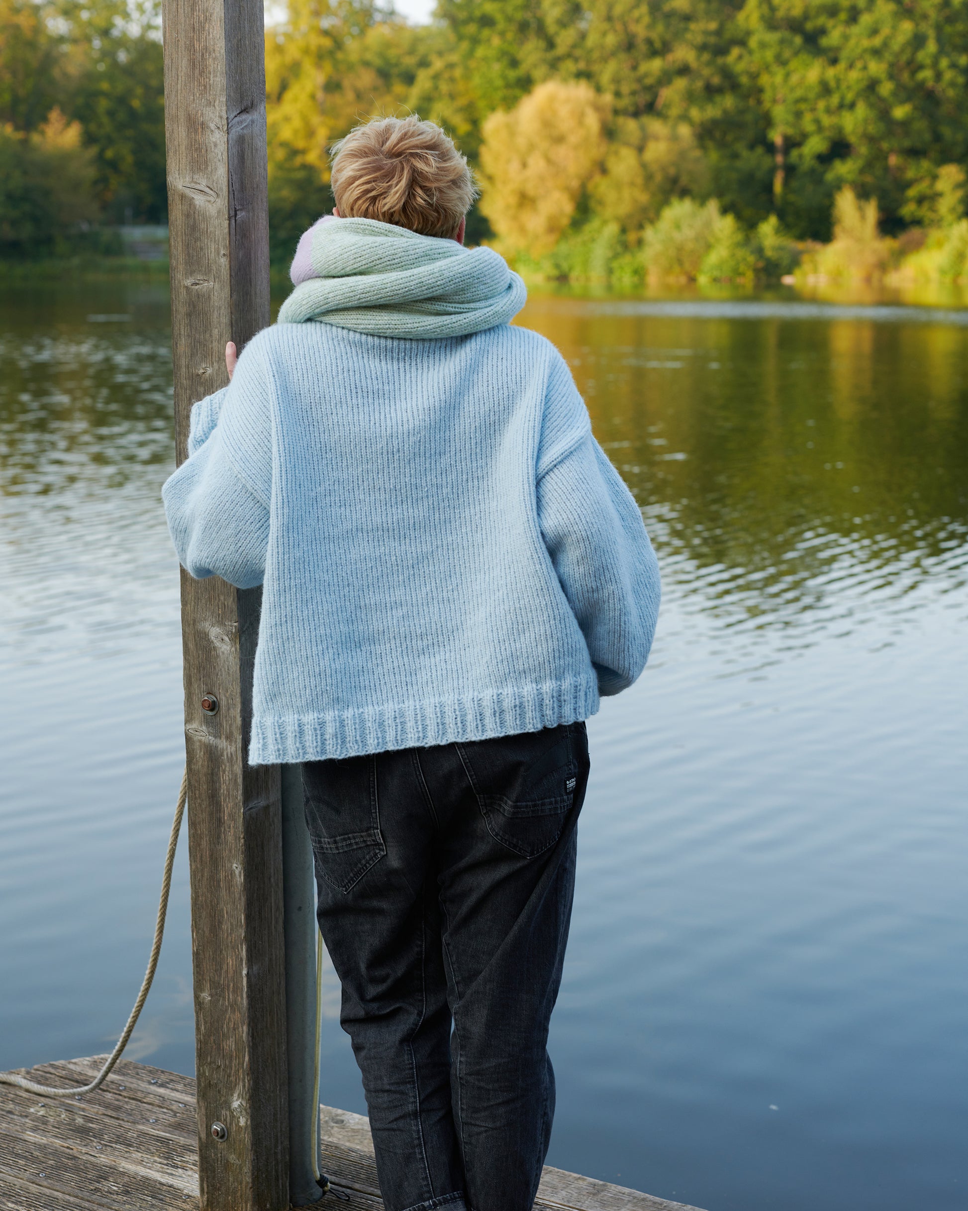 Alpaka Pullover HEIDI Rueckansicht an Model am See in der Farbe morgennebel