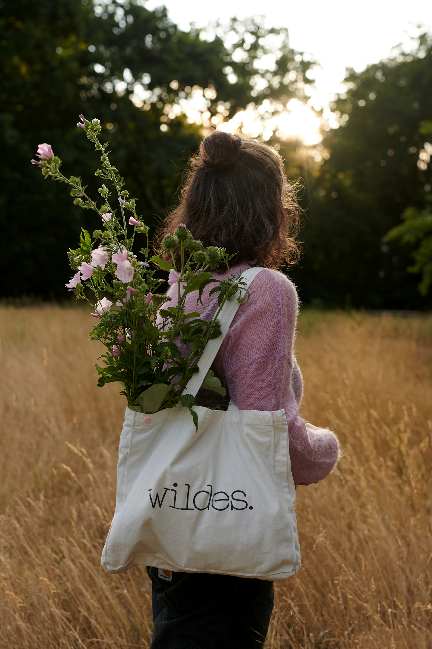 Baumwolltasche TINI mit Trägern hängend an Schulter mit Blumen