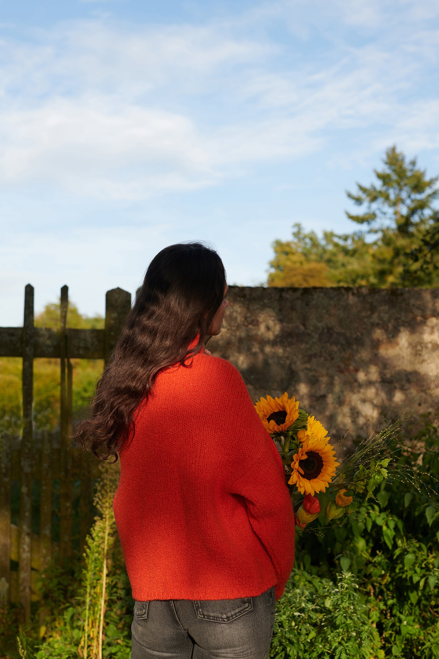 Boucle Pullover BETTY mit weitem Ärmel Rueckansicht an Model in der Farbe orangerot