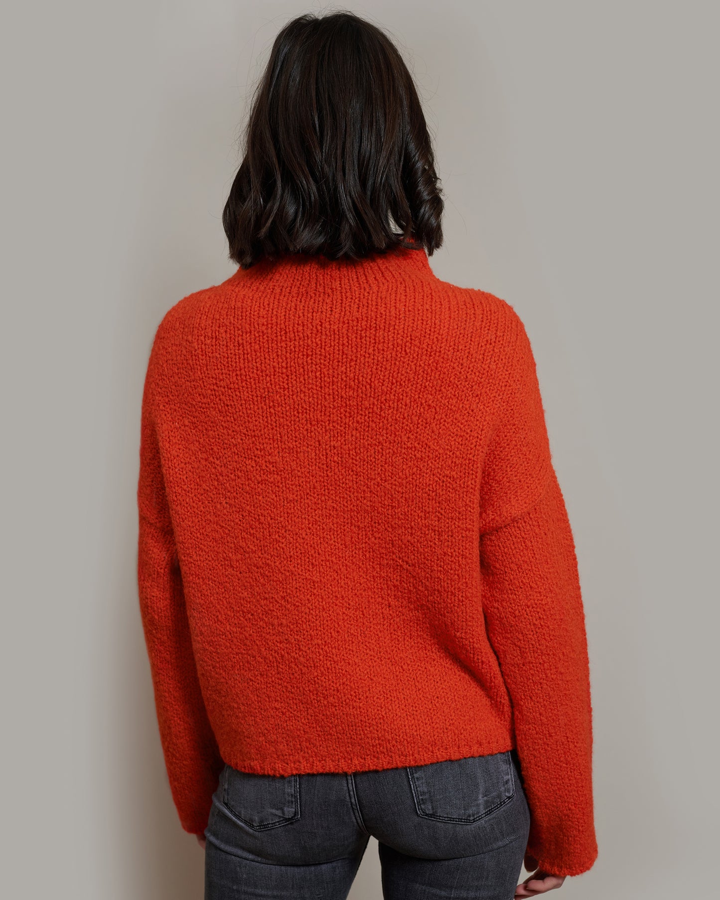 Boucle Pullover BETTY mit halsfernem Stehkragen Rueckansicht an Model in der Farbe orangerot