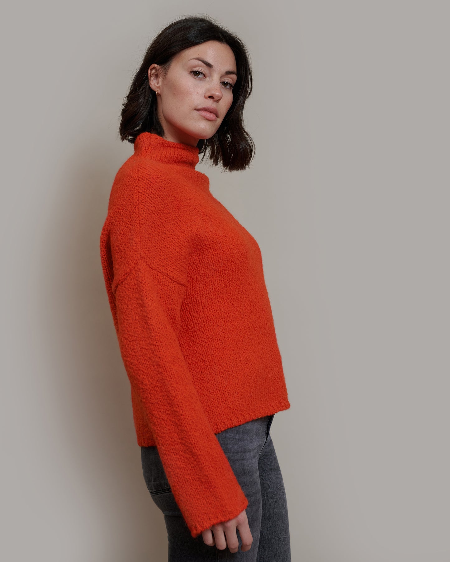 Boucle Pullover BETTY mit halsfernem Stehkragen und weitem Arm Seitenansicht an Model in der Farbe orangerot