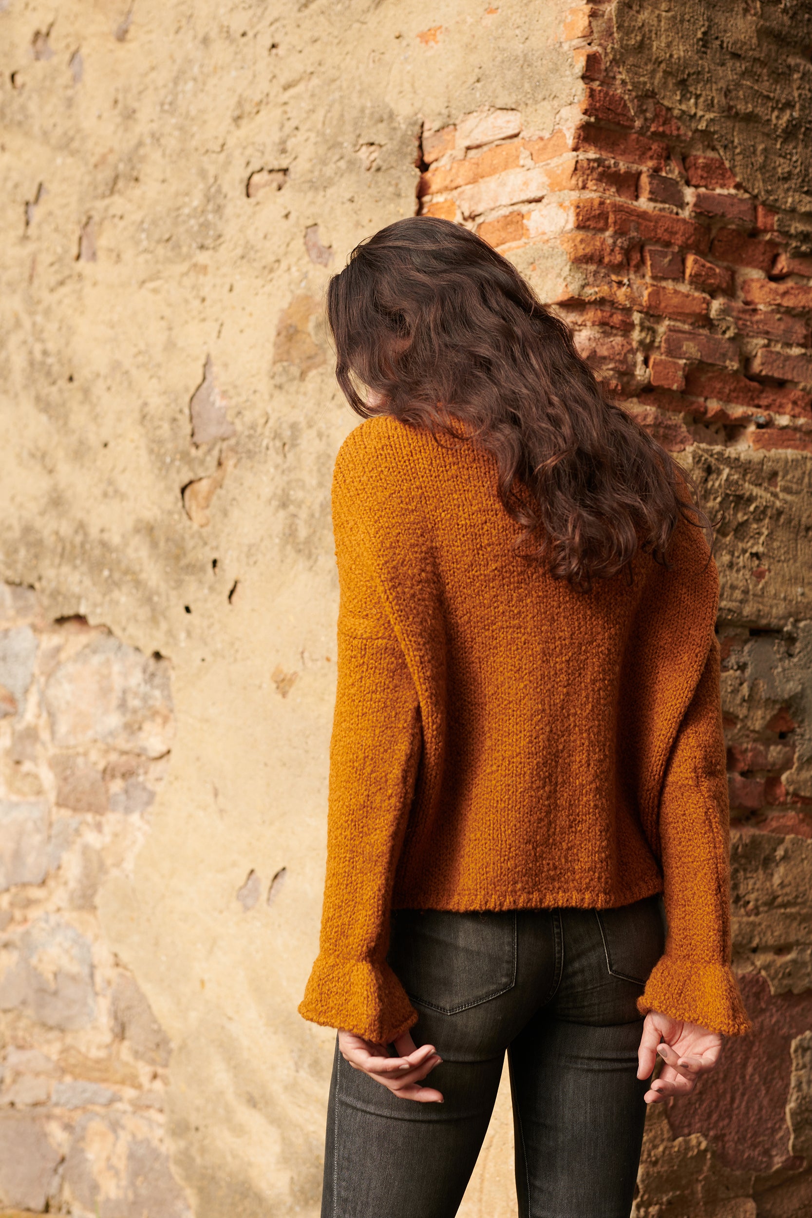 Boucle Pullover BOBBY mit halsfernem Stehkragen und Rueschenabschluss an Aermel Rueckansicht an Model in der Farbe cognac