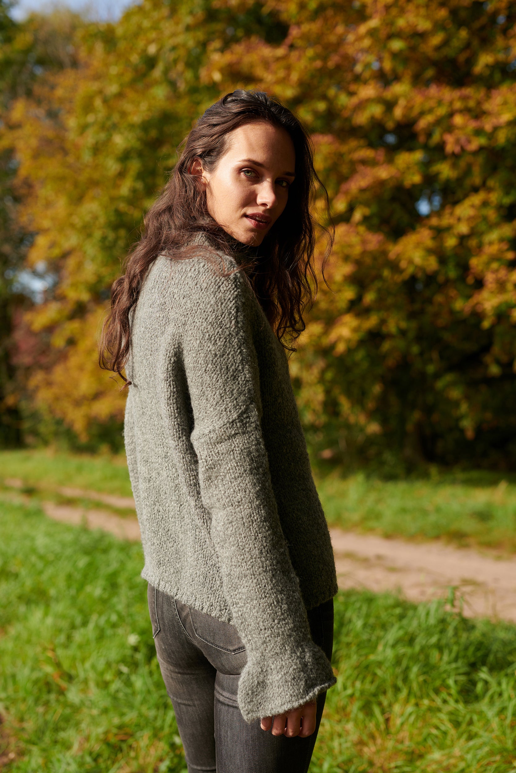 Boucle Pullover BOBBY mit halsfernem Stehkragen und Rueschenabschluss an Aermel Seitenansicht an Model in der Farbe grau