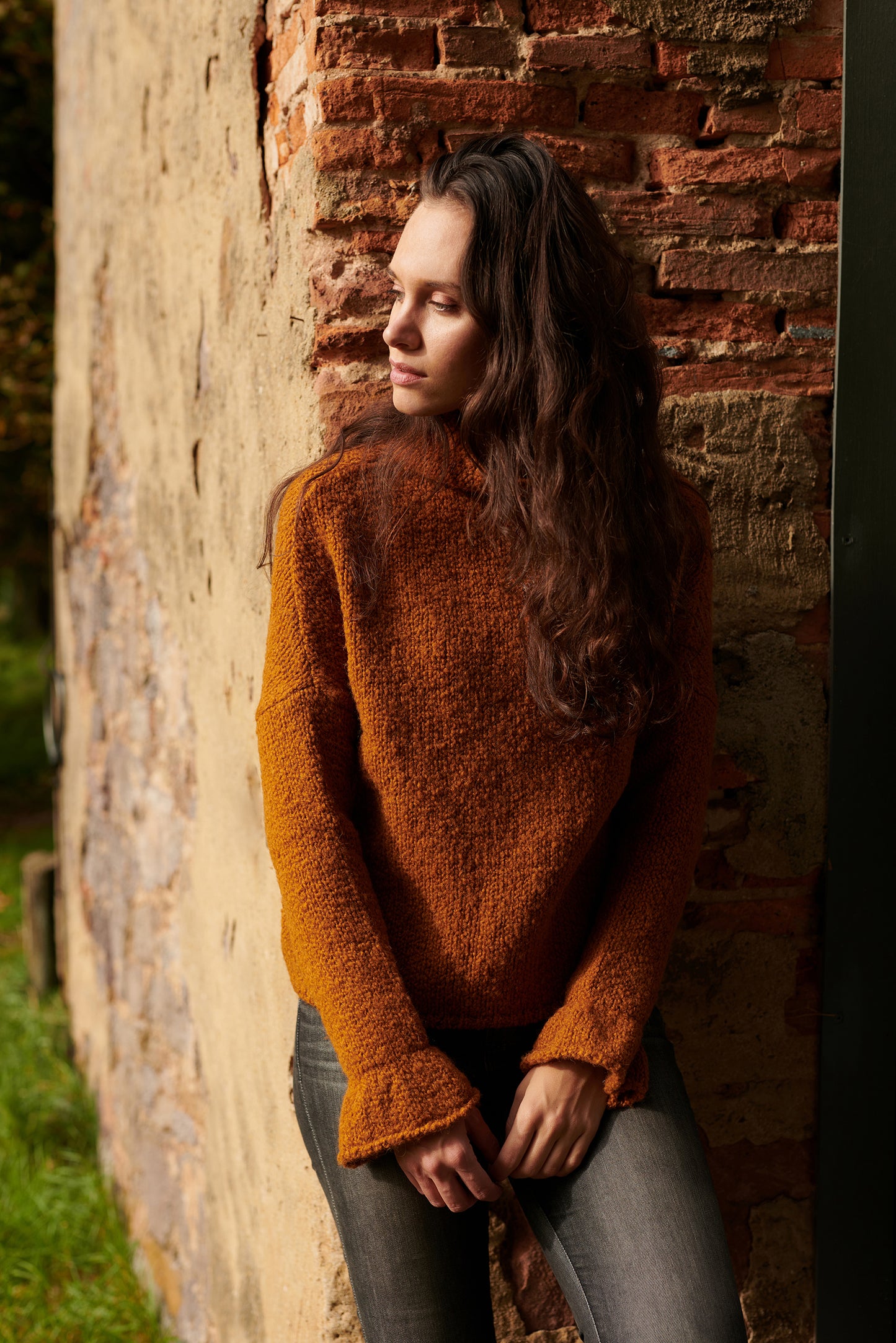 Boucle Pullover BOBBY mit halsfernem Stehkragen und Rueschenabschluss an Aermel Vorderansicht an Model in der Farbe cognac