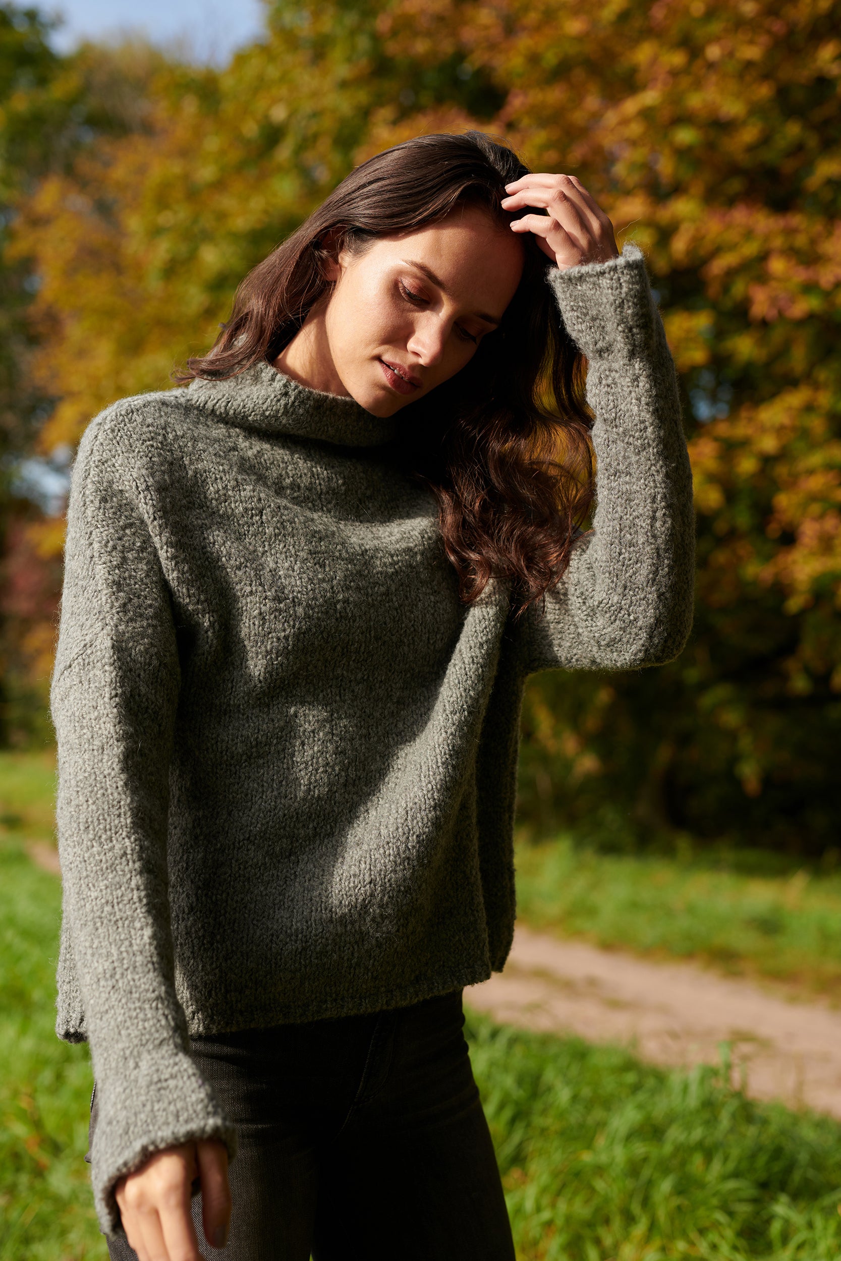 Boucle Pullover BOBBY mit halsfernem Stehkragen und Rueschenabschluss an Aermel Vorderansicht an Model in der Farbe grau