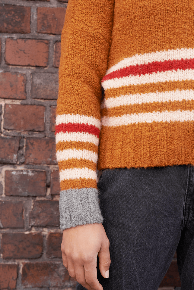 Boucle Pullover VANESSA mit farbigem Ringeldetail und Kontrastabschluessen an Aermel Detailansicht an Model in der Farbe cognac