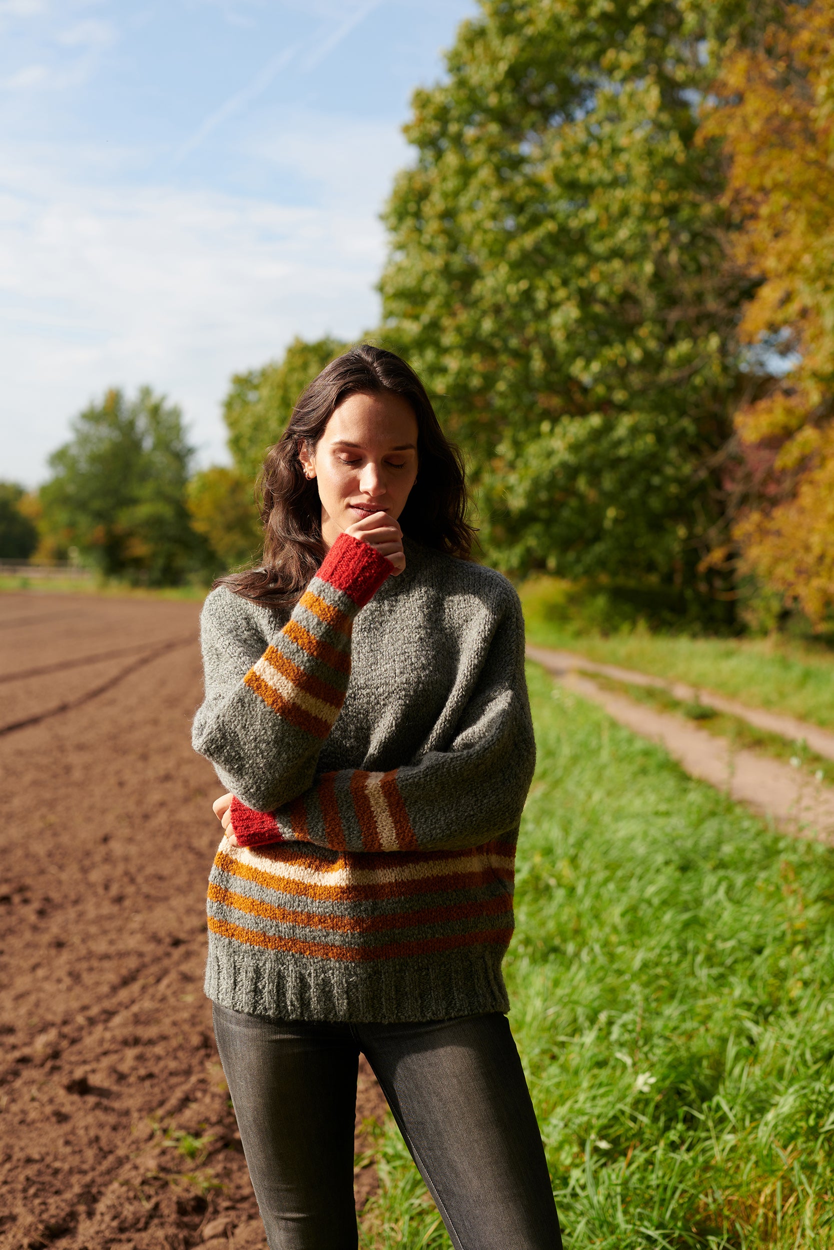 Boucle Pullover VANESSA mit farbigem Ringeldetail und Kontrastabschluessen an Aermel Vorderansicht an Model in der Farbe grau