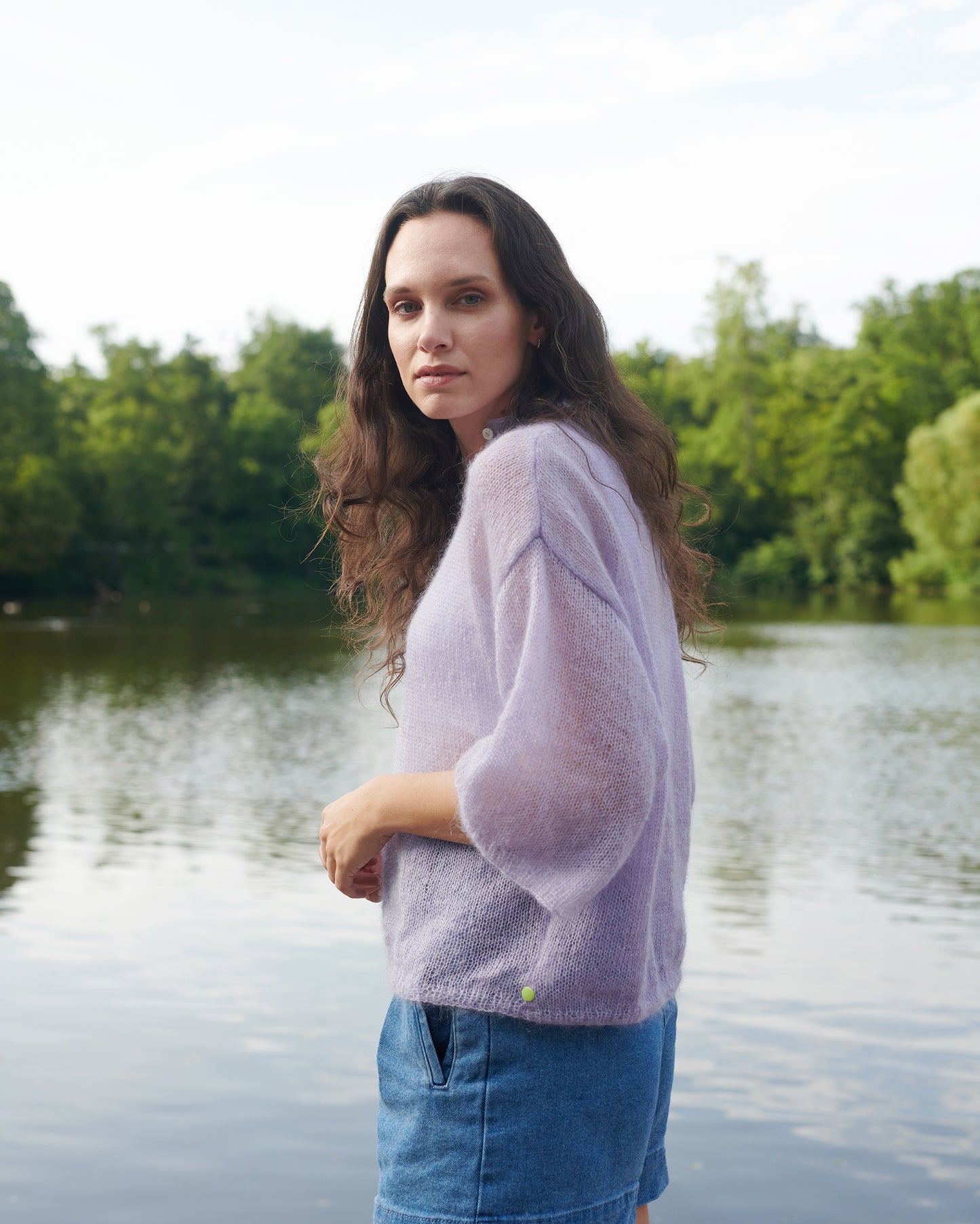 Mohair Seide Pullover FRIDA mit Rueschenkragen und Schlitz Seitenansicht an Model an See in der Farbe lila nebel.