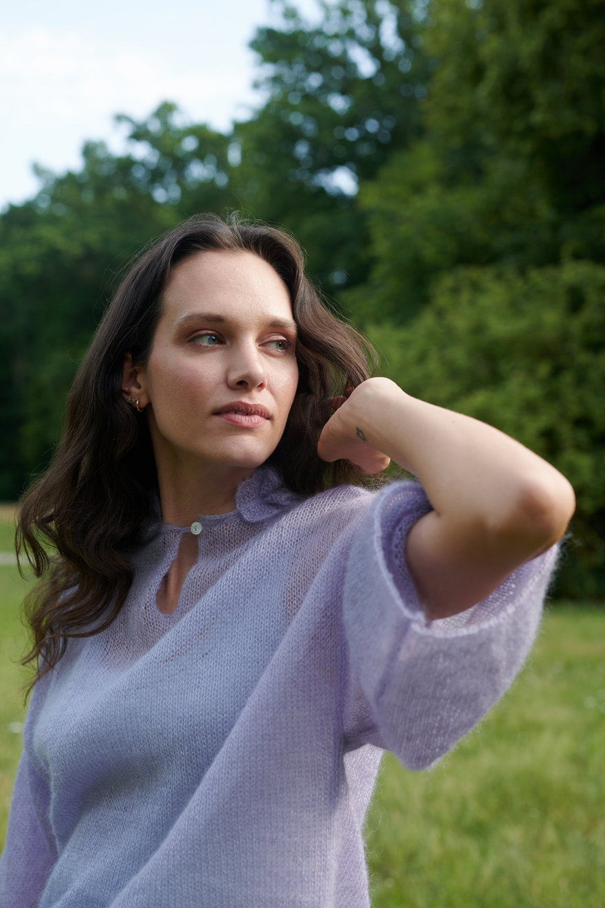 Mohair Seide Pullover FRIDA mit Rueschenkragen und Schlitz seitliche Vorderansicht geschlossen an Model  in der Farbe lila nebel.