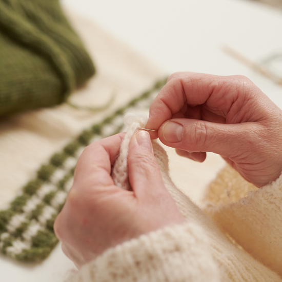 Zwei Hände nähen den wildes. Slowfashion Collegecardigan VIVIAN zusammen